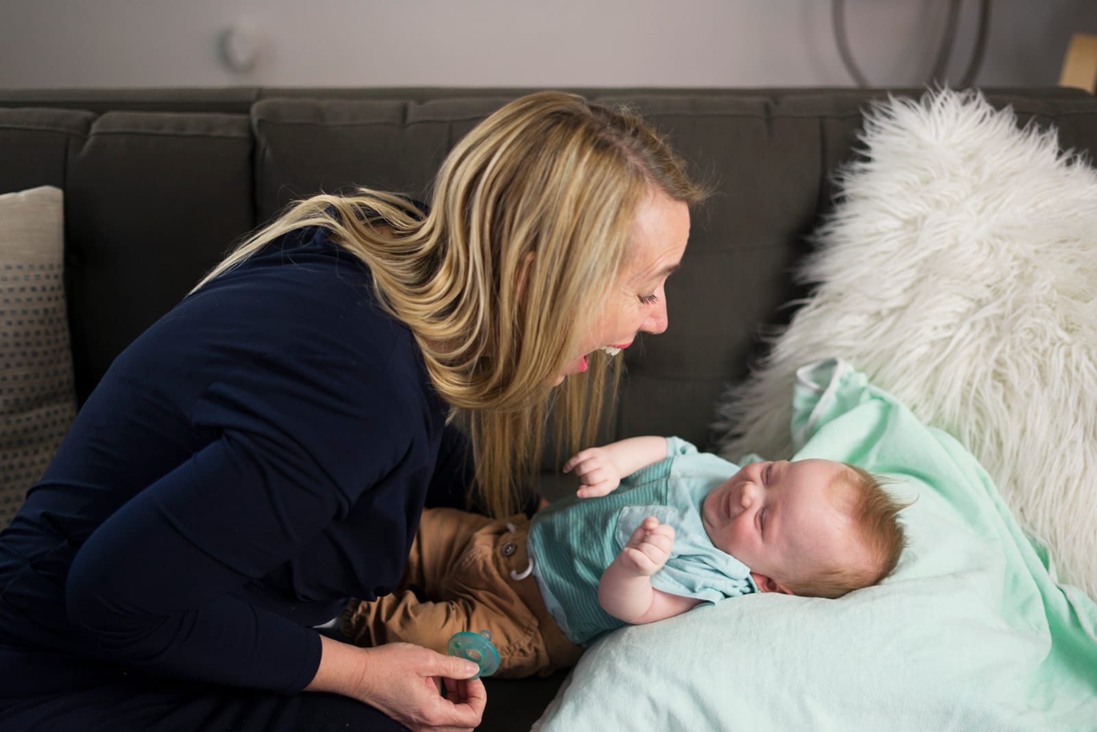 Julie leaning close to a baby lying on her lap during an assessment