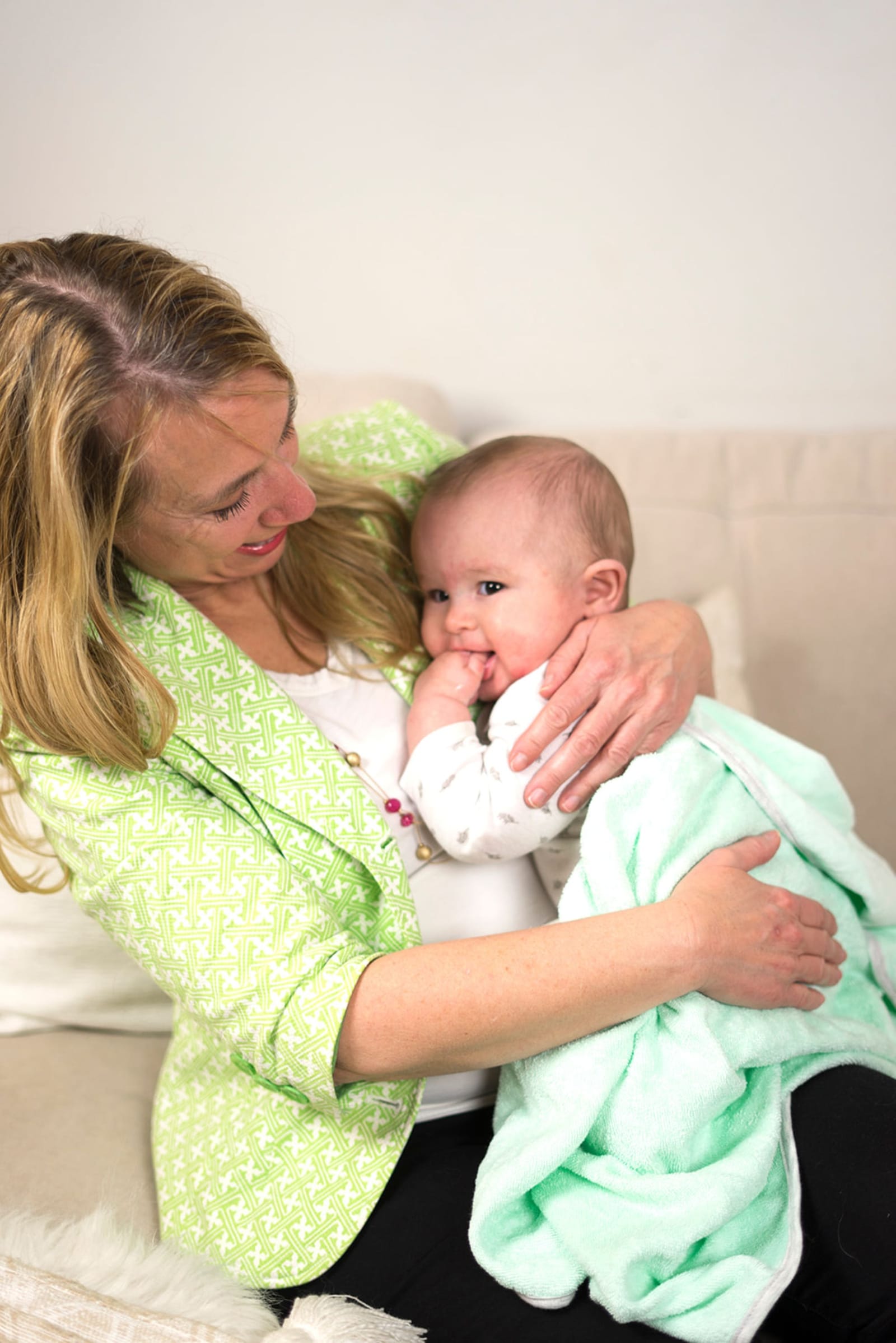 Julie Johnson cradling a baby wrapped in a mint blanket