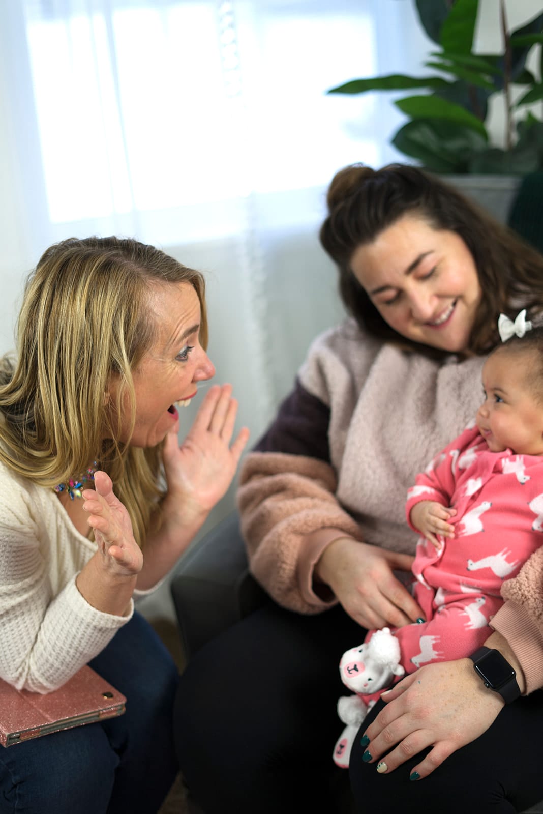 Julie high-fiving a mother who is holding her baby