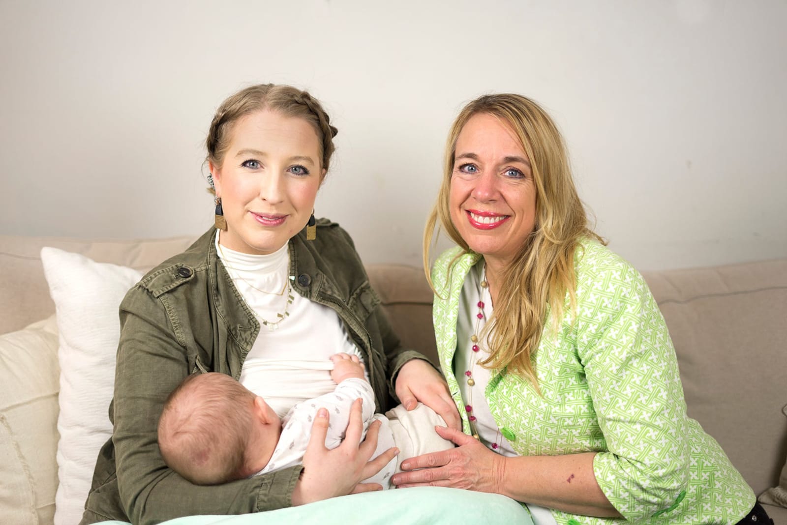 Julie sitting beside a mother who is nursing her newborn